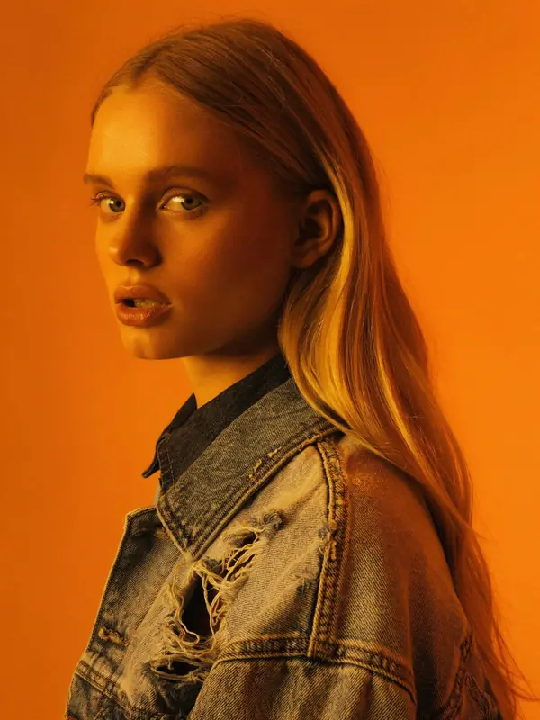FLUX.3 Klein: Portrait of a woman in a denim jacket against orange